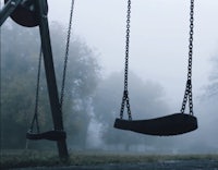 two swings in a park on a foggy day
